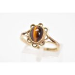 A 9CT GOLD GEM RING, designed with a central oval tigers-eye cabochon, within a scallop surround