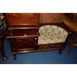 A REPRODUCTION OAK LINENFOLD TELEPHONE TABLE with an arched and single door upholstered seat,