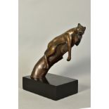 A 20TH CENTURY BRONZE FIGURE of lioness reclining on a tree stump, monogrammed mark beneath back