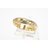 A 9CT GOLD DIAMOND SET BAND RING, the plain band with stepped edges, flush set with five brilliant