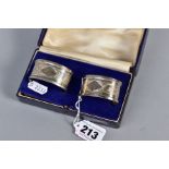 A CASED PAIR OF GEORGE V OVAL SILVER NAPKIN RINGS, maker H G & S, Birmingham 1933, 0.9ozt, 28 grams