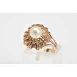 A RING, of a tiered floral design set with a central single cultured pearl, to the trifurcated