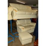 A CREAM LEATHER THREE PIECE SUITE comprising of a three seater settee, two seater settee and a