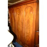 A VICTORIAN FLAME MAHOGANY TRIPLE DOOR WARDROBE, the left door with four internal linen slides,