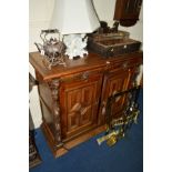 AN EARLY 20TH CENTURY OAK TWO DOOR CABINET with geometric panelled doors, two drawers flanked by