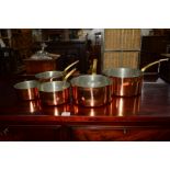 A SET OF FIVE COPPER GRADUATING PANS with brass hooped handles