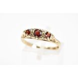 A 9CT GOLD GEM RING, of boat shape design, with a row of three graduated circular garnets
