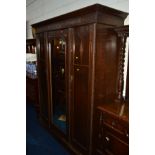 AN EARLY 20TH CENTURY OAK TWO PIECE BEDROOM SUITE comprising of a mirrored triple mirror door