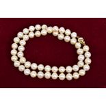 A CULTURED PEARL NECKLACE, designed as a uniform single row to the push piece spherical clasp,