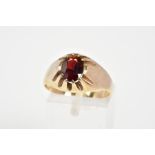 A 9CT GOLD GARNET RING, designed with a central oval cut garnet within an eight claw setting to