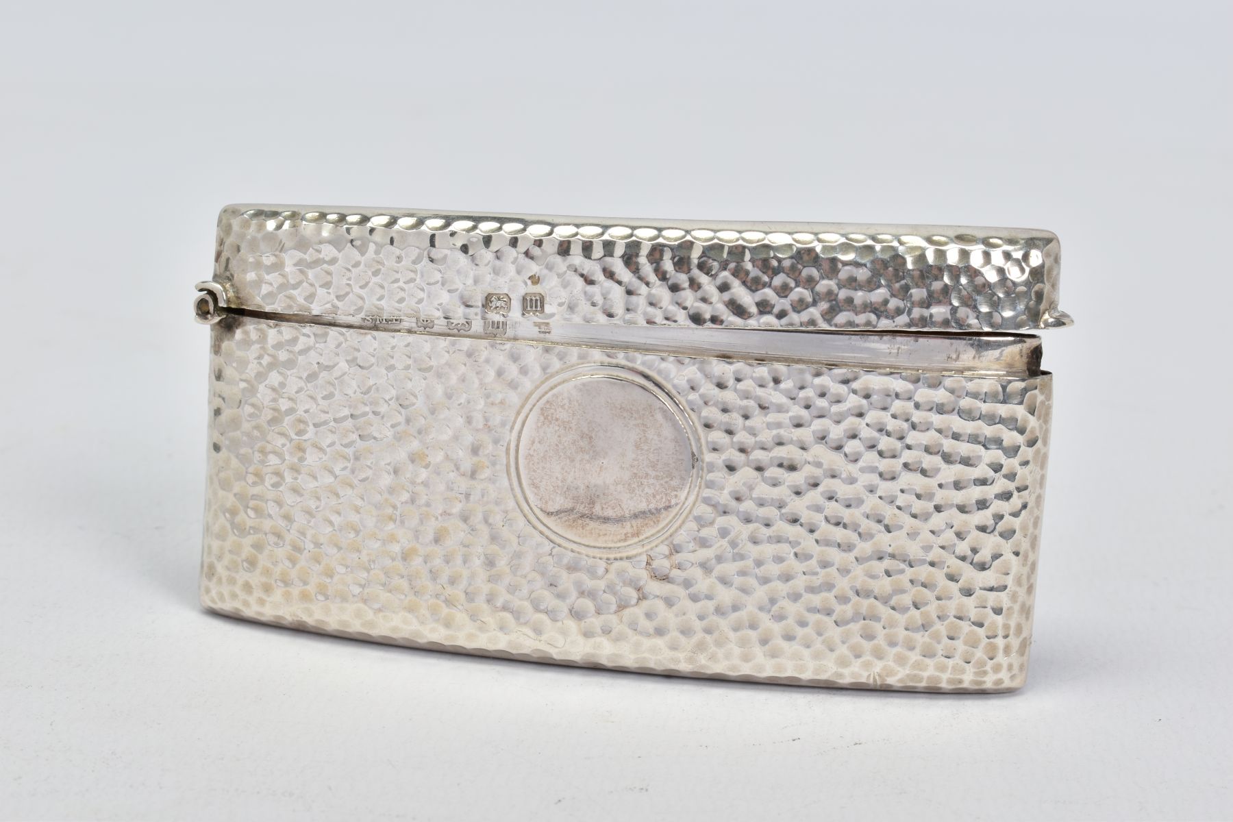 A GEORGE V SILVER RECTANGULAR CARD CASE OF BOWED FOR, hand hammered finish, vacant circular