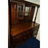 AN EARLY 20TH CENTURY OAK DRESSER the top with barley twist upright flanking a canted glazed