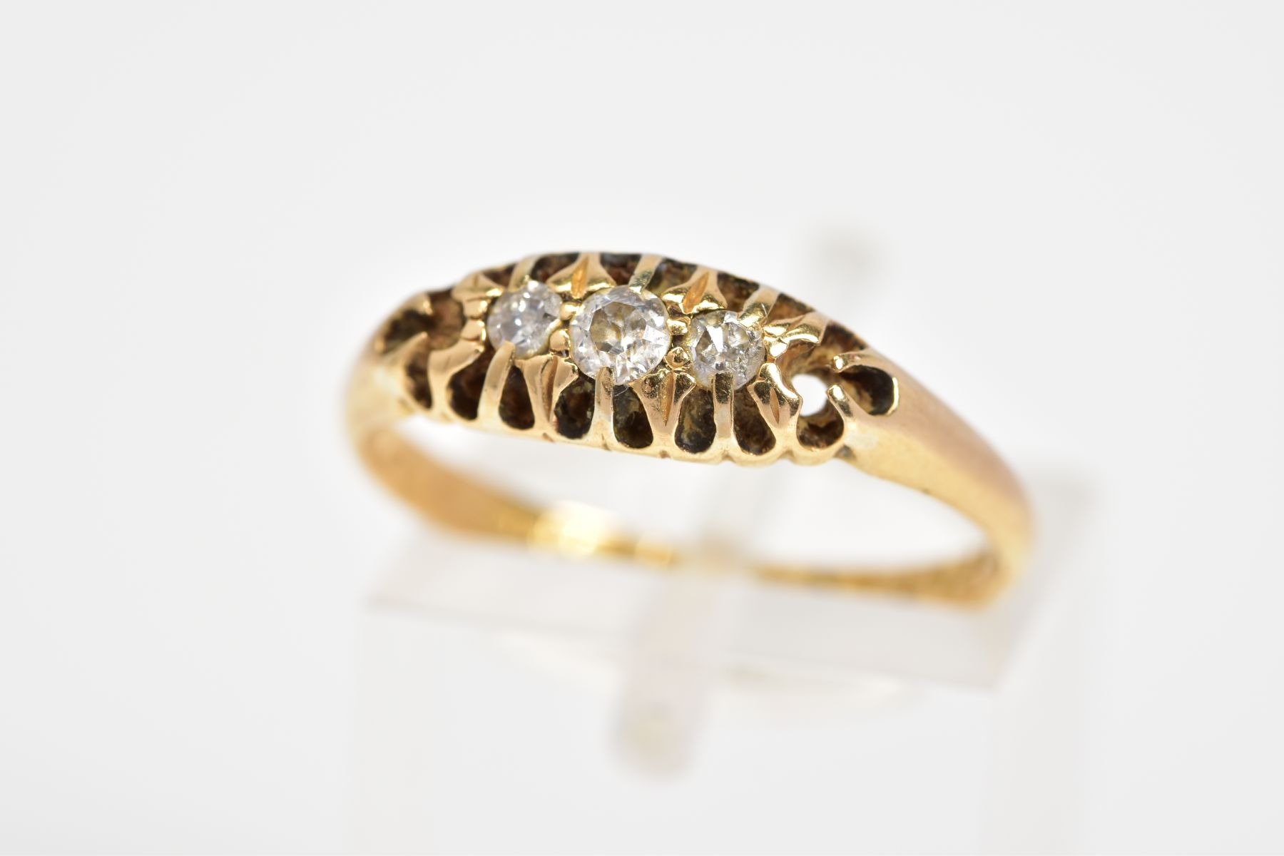 AN EARLY 20TH CENTURY 18CT GIOLD DIAMOND RING, designed as a row of three graduated old cut diamonds
