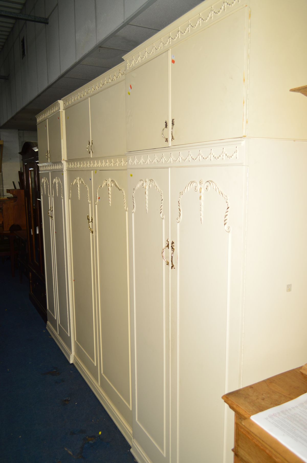 A CREAM AND GILT SIX PIECE BEDROOM SUITE, comprising three double door wardrobes with double door