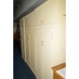 A CREAM AND GILT SIX PIECE BEDROOM SUITE, comprising three double door wardrobes with double door