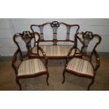 AN EDWARDIAN MAHOGANY THREE PIECE SALON SUITE, with foliate decoration and spindled splat backs,