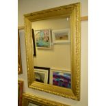 A MODERN FOLIATE GILT FRAMED WALL MIRROR, 115cm x 83cm