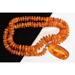 A MODIFIED AMBER NECKLACE AND PENDANT, the necklace designed as graduated disc shape beads to the