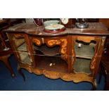 AN EDWARDIAN MAHOGANY AND INLAID BOW FRONT CABINET, flanked with glazed doors and an open shelf