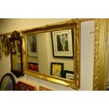 A MODERN GILT FRAMED WALL MIRROR, 106cm x 75cm