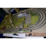 A 00 GAUGE MODEL RAILWAY LAYOUT, large double track oval with three sidings, laid on a chipboard