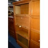 A LIGHT OAK FOUR SECTION BOOKCASE, three sections with glazed doors, one section with a panelled
