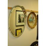 A PAINTED OVAL WALL MIRROR with carved rose decoration, together with a modern gilt framed