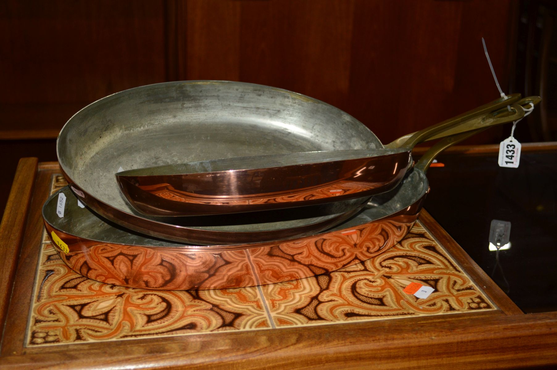 A SET OF THREE GRADUATING OVAL COPPER PANS, with brass hooped handles