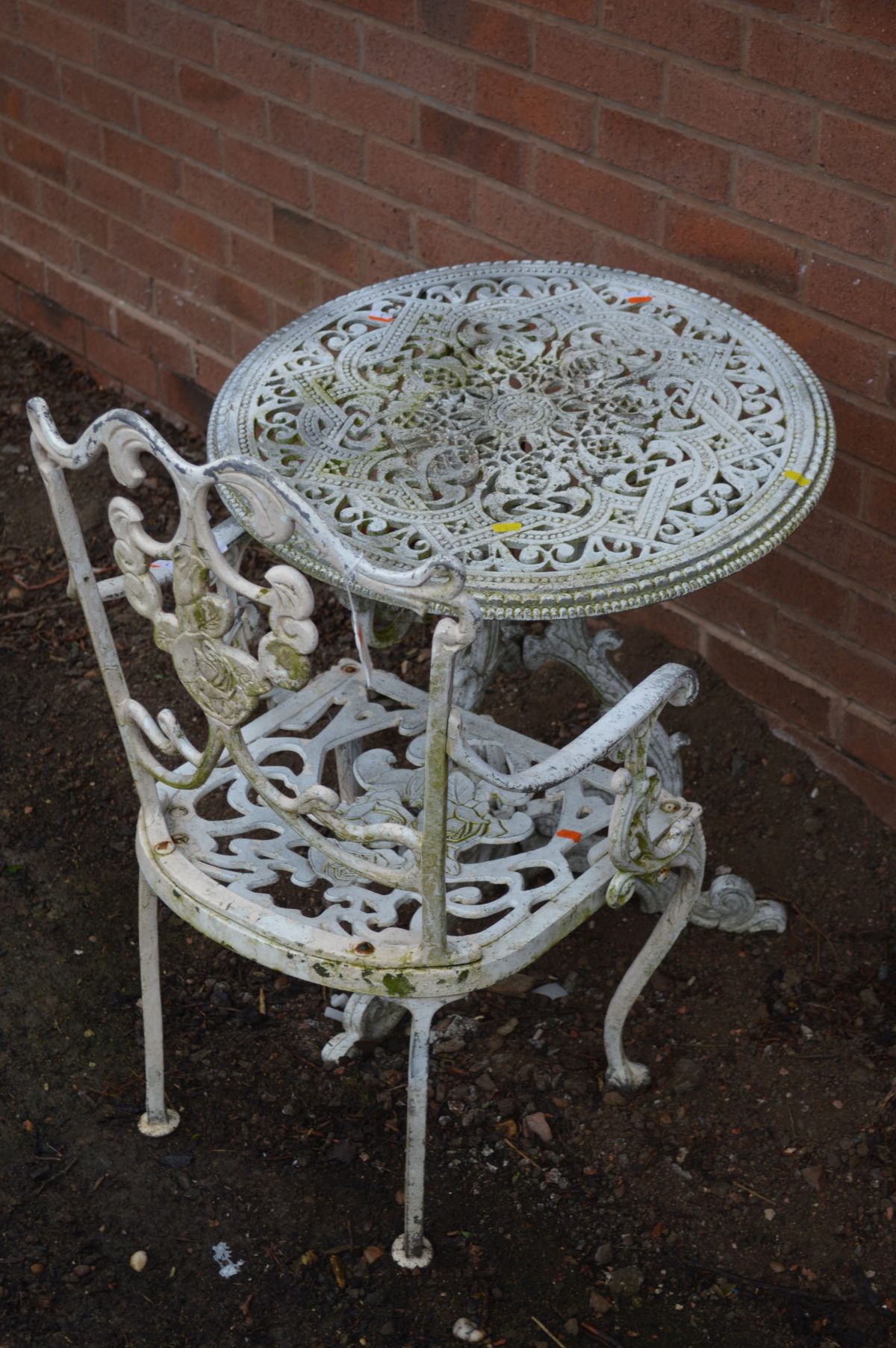 A WHITE PAINTED ALUMINIUM CIRCULAR GARDEN TABLE and a matching chair (2)