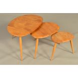 AN ERCOL BLONDE ELM PEBBLE NEST OF THREE TABLES, on triple beech cylindrical tapering legs,