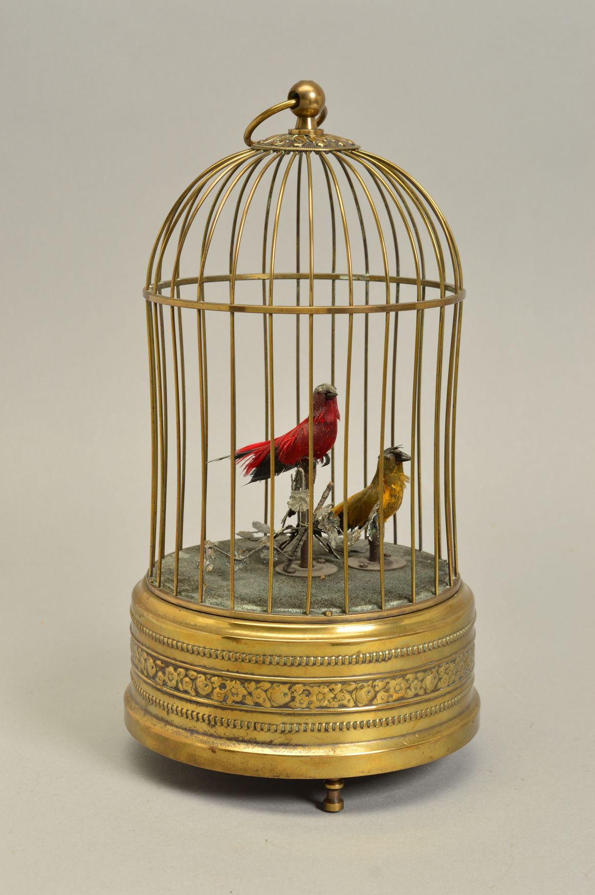 AN EARLY 20TH CENTURY CLOCKWORK AUTOMATON OF TWO BIRDS IN A BRASS CAGE, both birds sing and move