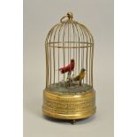 AN EARLY 20TH CENTURY CLOCKWORK AUTOMATON OF TWO BIRDS IN A BRASS CAGE, both birds sing and move