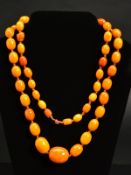 A NATURAL AMBER NECKLACE, designed as fifty-five graduated beads measuring approximately 13mm to