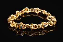 AN EARLY 20TH CENTURY GOLD, SAPPHIRE AND SEED PEARL BRACELET, designed as a twisted curb link