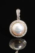 A MODERN 18CT WHITE GOLD MABE PEARL AND DIAMOND PENDANT, a round Mabe pearl enclosed within a border