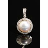 A MODERN 18CT WHITE GOLD MABE PEARL AND DIAMOND PENDANT, a round Mabe pearl enclosed within a border