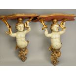 A PAIR OF LATE 19TH/EARLY 20TH CENTURY GILDED AND PAINTED WOODEN PUTTI SUPPORT WALL SHELVES, the