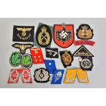 A BOX CONTAINING A NUMBER OF BELIEVED GENUINE GERMAN WWI/WWII CLOTH INSIGNIA, including a large