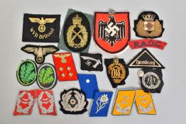 A BOX CONTAINING A NUMBER OF BELIEVED GENUINE GERMAN WWI/WWII CLOTH INSIGNIA, including a large