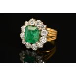A LATE 20TH CENTURY LARGE EMERALD AND DIAMOND CLUSTER RING, emerald cut emerald measuring