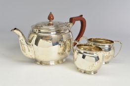 A GEORGE VI SILVER THREE PIECE TEA SERVICE, of oval form, brown bakelite handle and finial to the