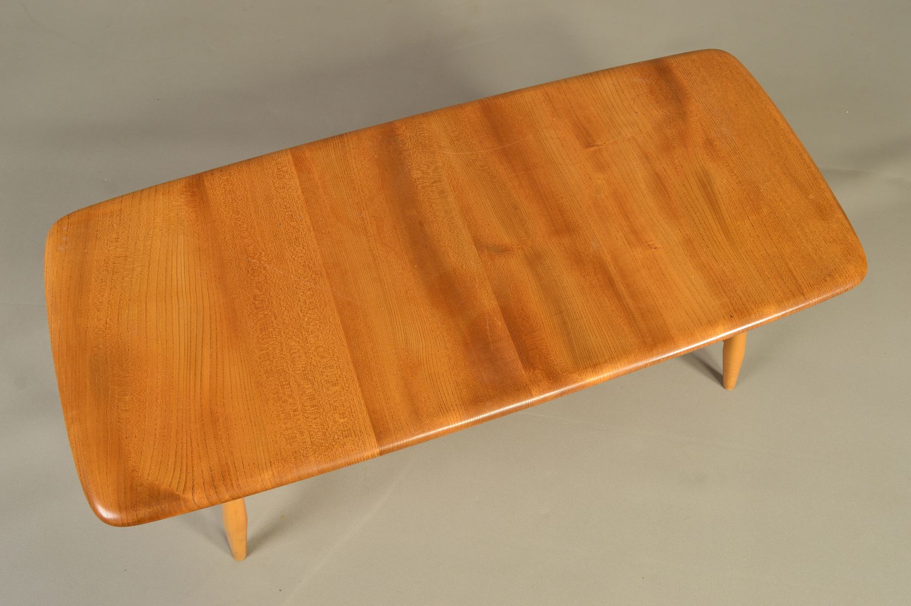 AN ERCOL BLONDE ELM RECTANGULAR COFFEE TABLE, on four beech tapering legs united by a spindled - Image 2 of 6
