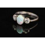AN 18CT WHITE GOLD, OPAL AND DIAMOND RING, designed as a central oval opal cabochon flanked to