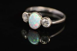 AN 18CT WHITE GOLD, OPAL AND DIAMOND RING, designed as a central oval opal cabochon flanked to
