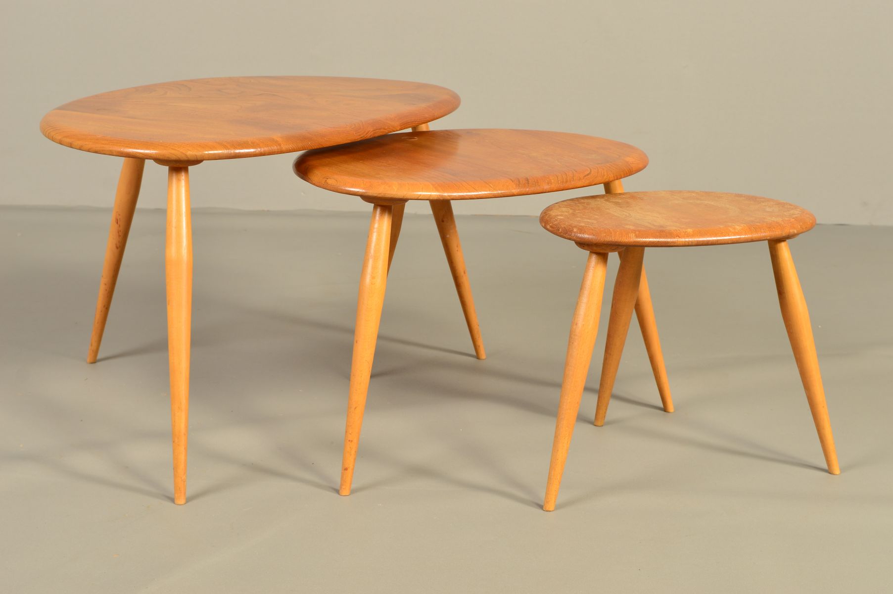 AN ERCOL BLONDE ELM PEBBLE NEST OF THREE TABLES, on triple beech cylindrical tapering legs, - Image 2 of 6