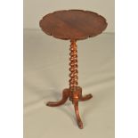 A VICTORIAN ROSEWOOD AND ROSEWOOD STAINED TRIPOD TABLE, the wavy circular top on a spiral twist