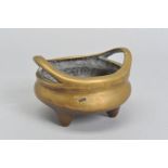 A CHINESE POLISHED BRONZE TRIPOD CENSER, 18th / 19th Century, looped handles, cast mark to