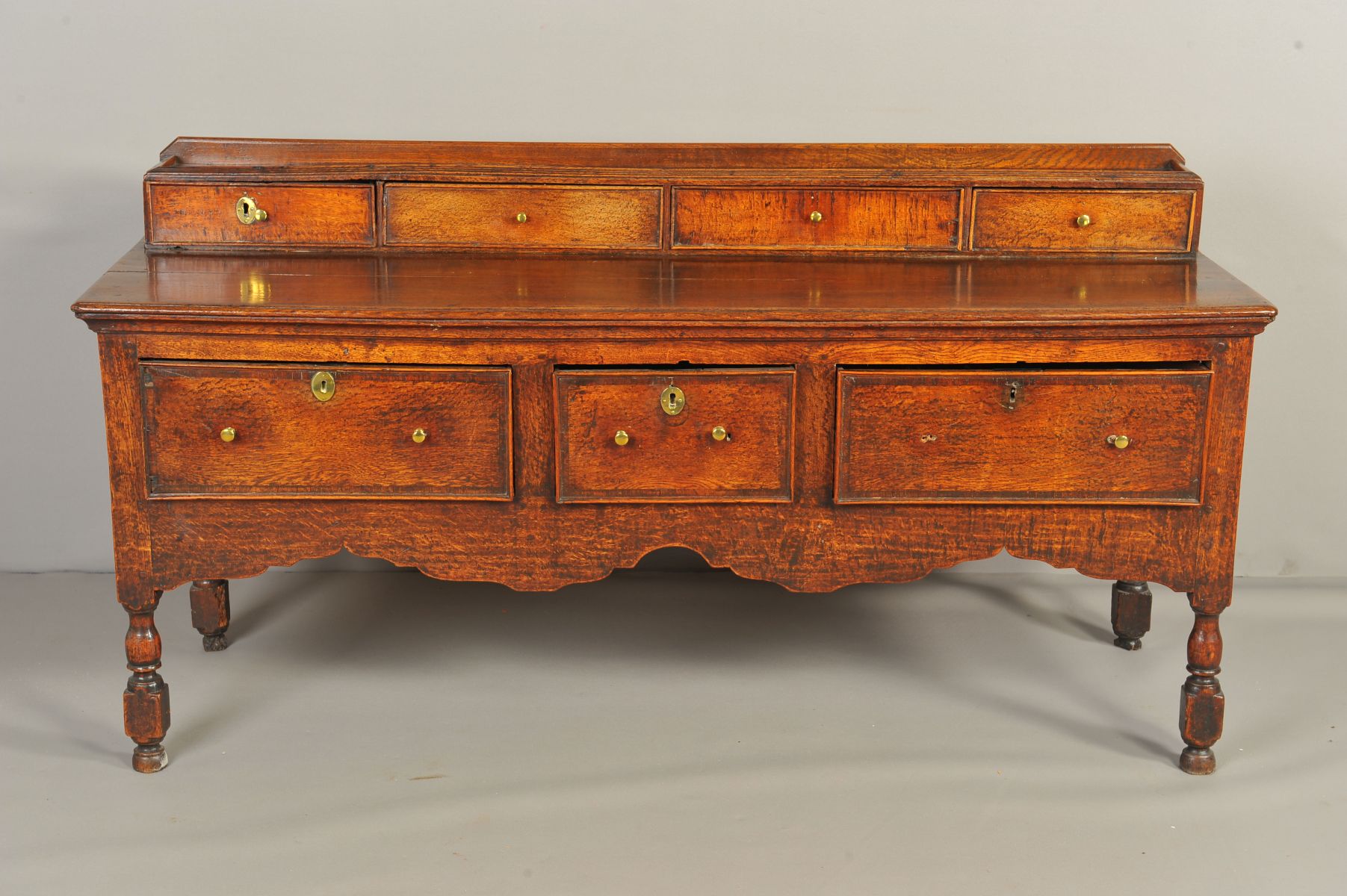 A MID 18TH CENTURY AND LATER OAK DRESSER, the short raised back above an arrangement of four drawers