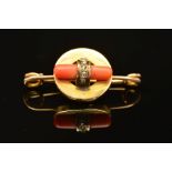 AN ART DECO GOLD, CORAL AND DIAMOND BROOCH, designed as a central circular panel encasing a polished