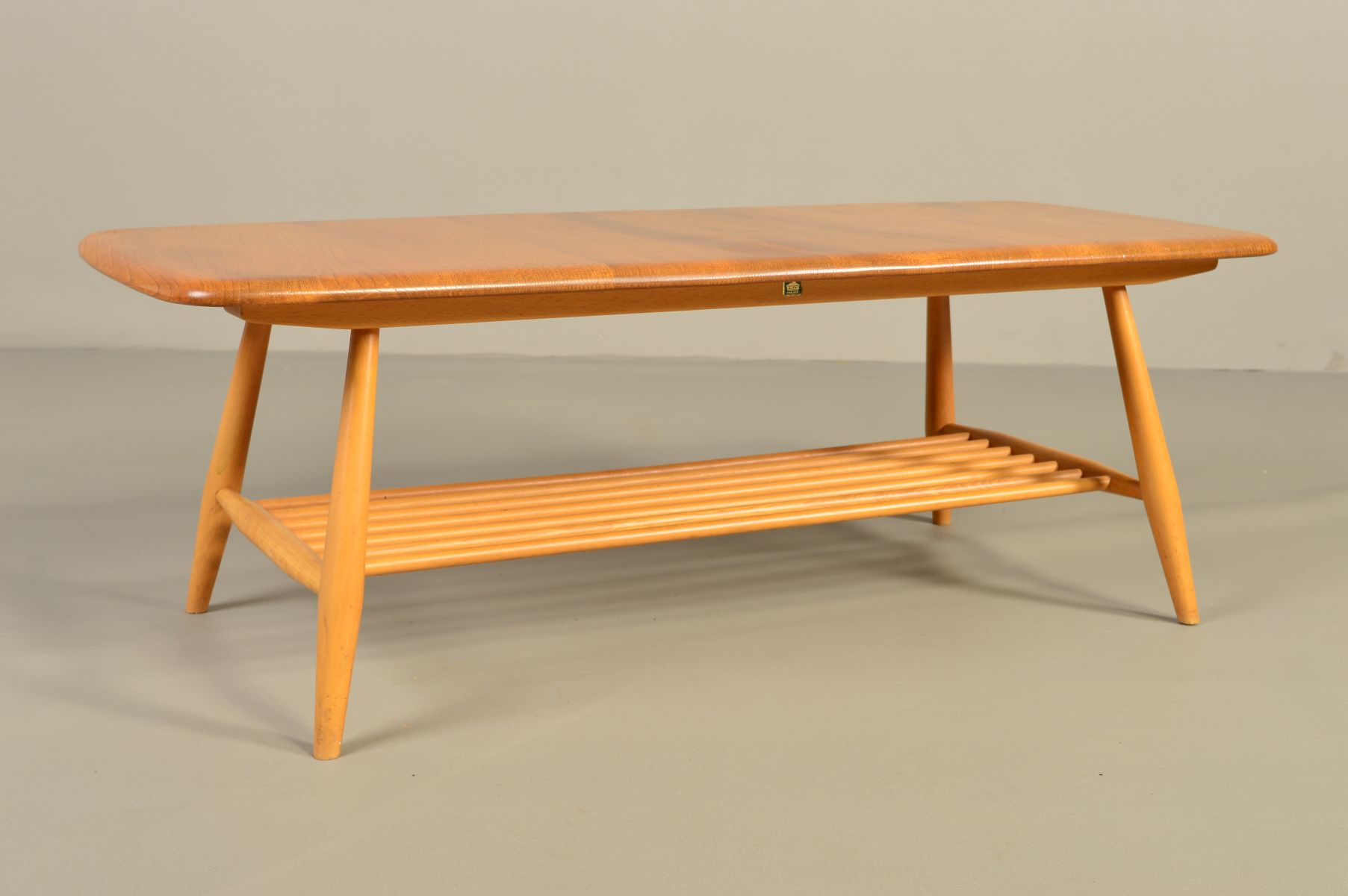 AN ERCOL BLONDE ELM RECTANGULAR COFFEE TABLE, on four beech tapering legs united by a spindled - Image 3 of 6